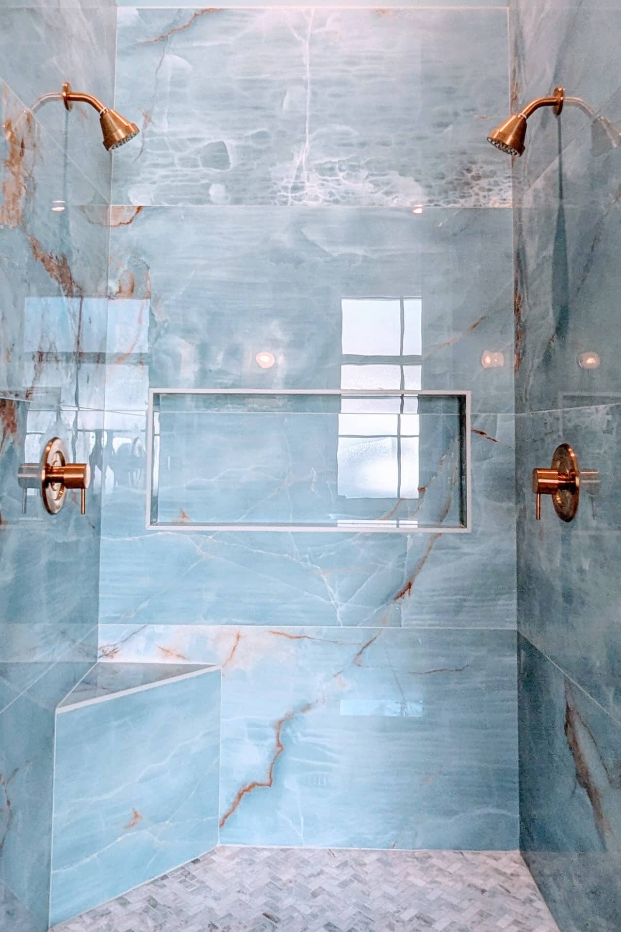 beautiful tile installation with golden bronze shower heads