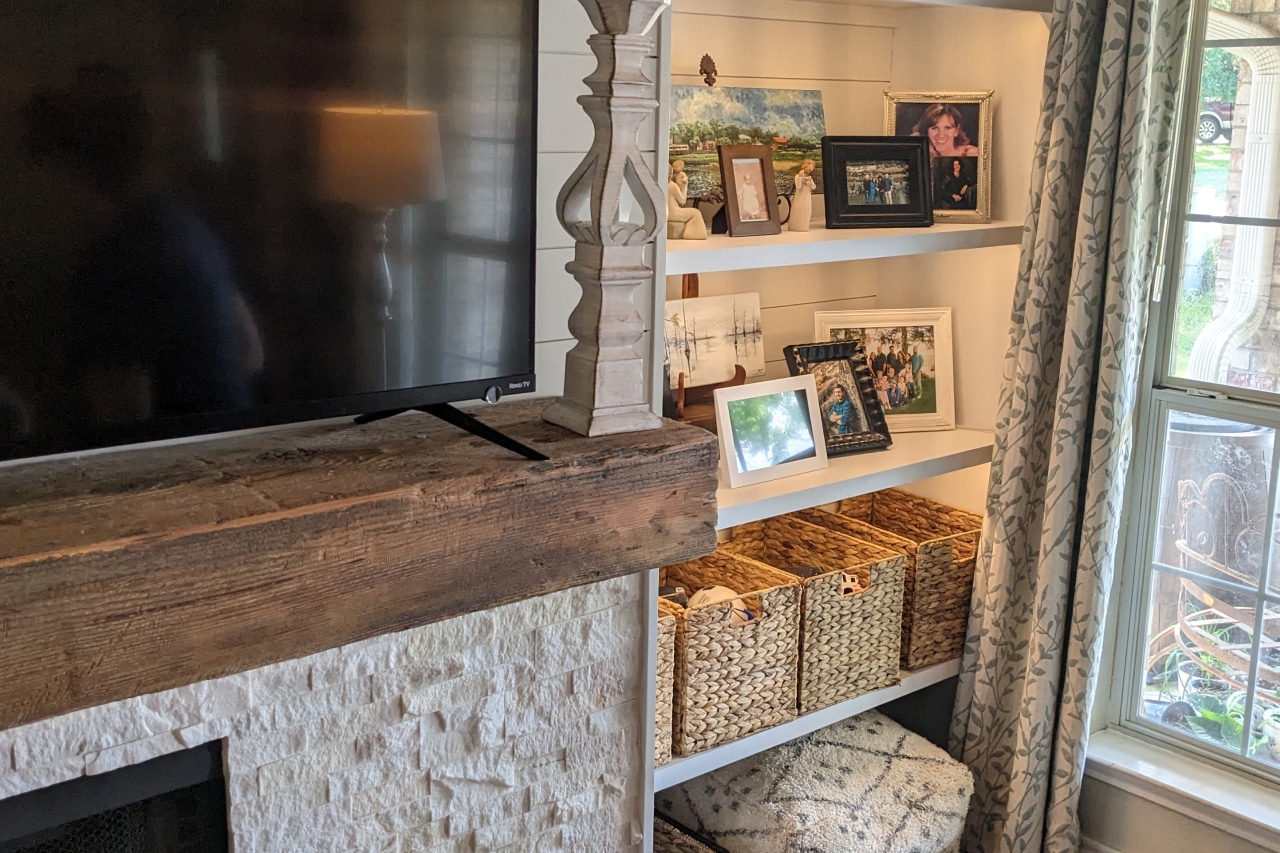 side of the tv in the living room full of family pictures with frame